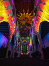 Das Bild zeigt einen Ausschnitt aus Genesis II. Die Minoritenkirche wird innen mit bunten Bild- und Videoprojektionen bespielt.