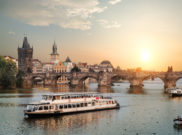 Ausflugsschiff auf der Moldau vor der Prager Altstadt im romantischen Sonnenuntergang