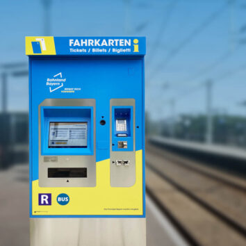 Auf dem Bild sieht man einen Fahrkartenautomaten auf dem Bahngleis.Auto