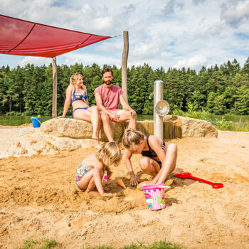 Sand spielende Kinder im Matschbereich am Badeplatz des Hammersee.