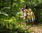 Mutter mit Kindern beim Wandern durch den Wald