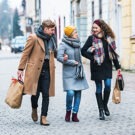 Gruppe aus Mann, Frau und Oma beim shoppen im Winter in einer Fußgängerzone