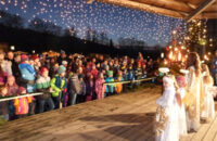 Auftritt von Kindern, die als Engel verkleidet sind auf eine weihnachtlich beleuchteten Bühne