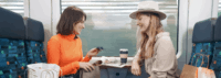 Zwei Frauen sitzen nach einer Shoppingtour im Zug.