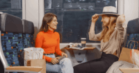 Zwei Frauen sitzen nach einer Shoppingtour im Zug.