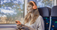 Eine Frau hört Musik im Zug.