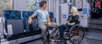 Eine Frau im Rollstuhl ist auf den dafür vorgesehenen Stellplatz im Zug.