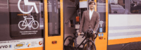 Mann steigt mit Fahrrad aus dem Zug aus.