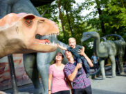 Familie neben einem Dinosaurier im Saurierpark Kleinwelka