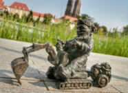 Ein kleiner Metall-Zwerg auf einem Bagger in der Stadt Wroclaw.