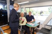 Vogtlandbahn-Fahrgastbetreuerin bei Kontrolle und Verkauf eines Tickets im Zug