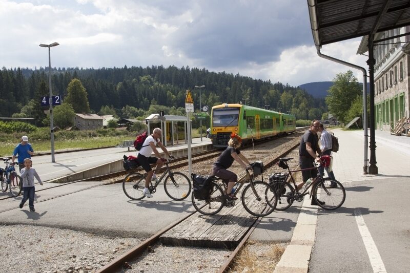 Fahrradfahrer sind mit der waldbahn angekommen und fahren jetzt mit dem Fahrrad weiter