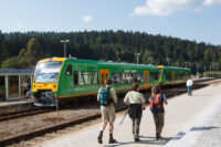 Menschen auf dem Bahnsteig vor der waldbahn