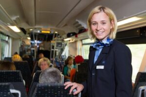 Kundenbetreuerin im Zug wie sie die Fahrgäste betreut