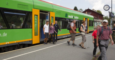 Eine Menschenmenge steigt an einem waldbahn-Bahnhof von der waldbahn aus