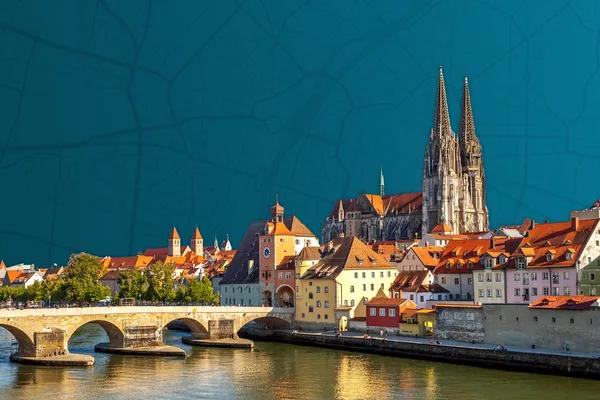 Blick auf die Steinerne Brücke und den Regensburger Dom. Die bunten Fassaden der Häuser leuchten im Sonnenlicht.