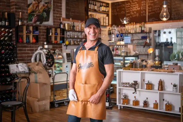 Innenaufnahme eines stilvollen Cafés mit Weinregal, Kaffeemaschine und dekorativen Elementen, warme Lichtstimmung.
