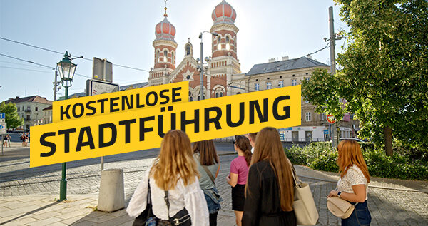 Eine Gruppe von Teilnehmenden steht bei einer Stadtführung auf einem Platz, im Hintergrund die Große Synagoge von Pilsen; darüber der Schriftzug „Kostenlose Stadtführung“.