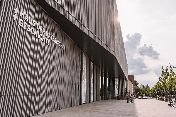 Moderne Fassade des Museums mit Schriftzug ‚Haus der Bayerischen Geschichte‘ und breitem Eingangsbereich.