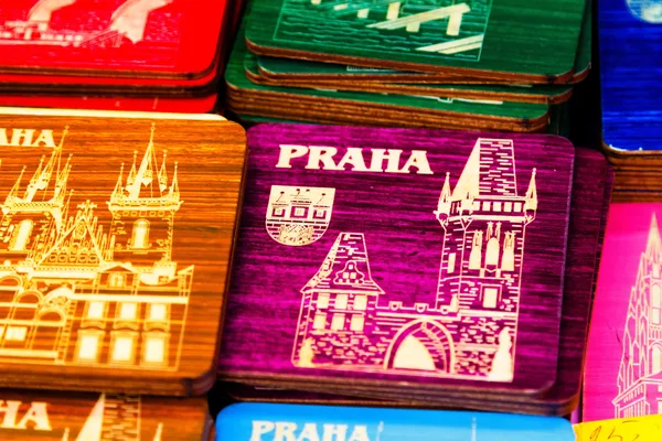 Bunte Holzuntersetzer mit Aufdruck ‚Praha‘ und Motiven der Prager Architektur.