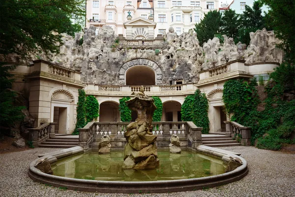 Historischer Grotta-Brunnen mit der Statue des Neptun, umgeben von klassizistischer Architektur in den Havlíček-Gärten (Grébovka) in Prag.
