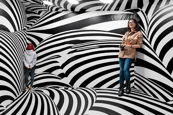 Raum mit schwarz-weißen Streifenmustern, die optische Täuschungen erzeugen.