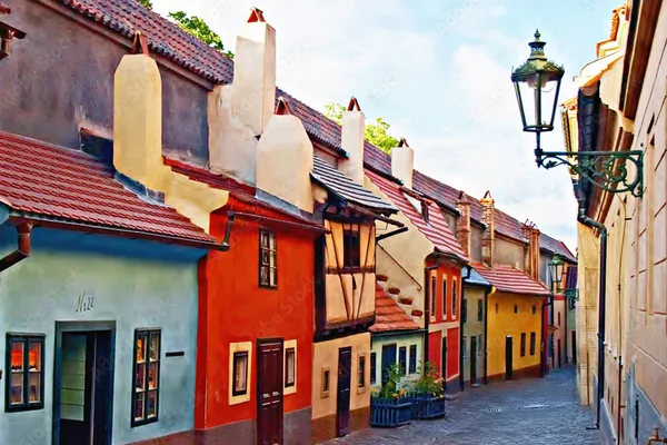Historische Häuser mit bunten Fassaden und kleinen Fenstern in einer engen Gasse.