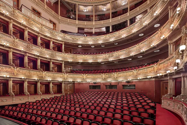 Prunkvoller Opernsaal mit roten Sitzen, goldenen Verzierungen und mehreren Rängen.