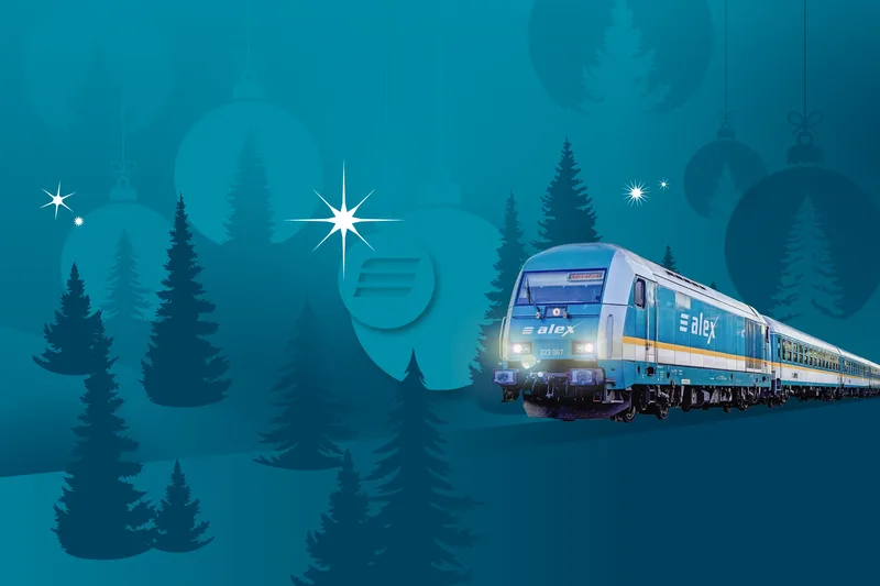 alex-Zug fährt durch eine grafisch dargestellte, winterliche Landschaft mit Tannenbäumen und Weihnachtsdekoration.