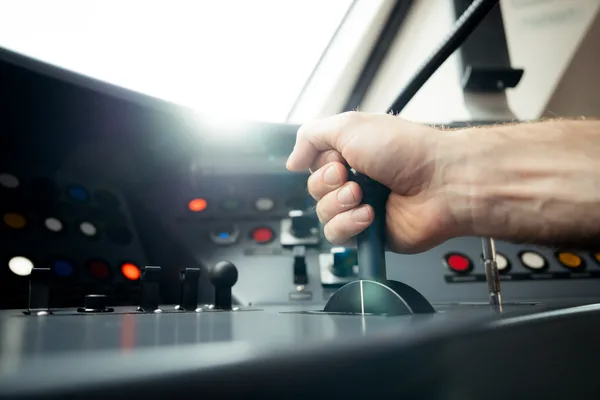 Hand betätigt Hebel im Führerstand eines Zuges.