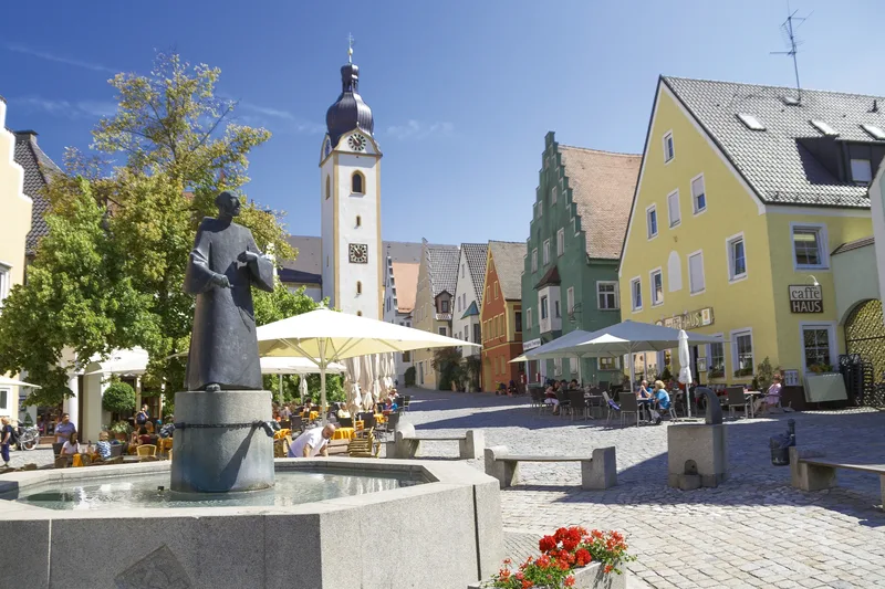 Stadtplatz mit Brunnenfigur, Sitzgelegenheiten und historischen Gebäuden