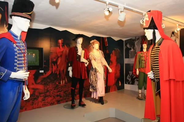 Museumsausstellung mit historischen Uniformen und Kleidern auf Schaufensterpuppen