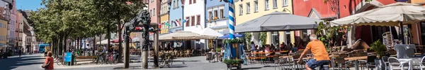 Marktplatz mit bunten historischen Fassaden, Außengastronomie und Radverkehr