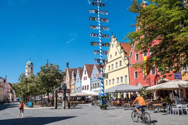 Marktplatz mit bunten historischen Fassaden, Außengastronomie und Radverkehr