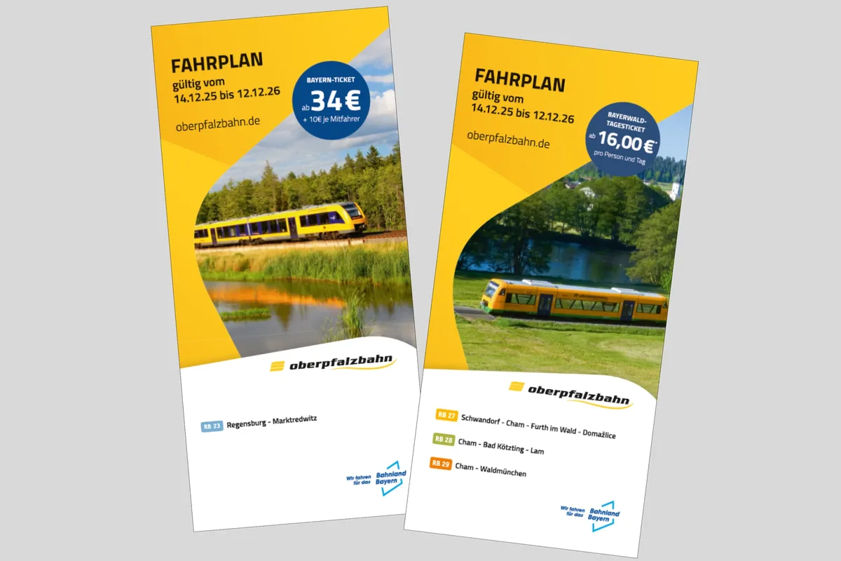 Zwei Flyer mit dem Titel „FAHRPLAN“ liegen auf einer grauen Fläche.
