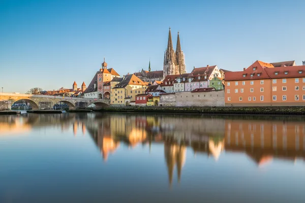 Historické centrum Regensburgu s katedrálou, Kamenným mostem a odrazem v Dunaji.