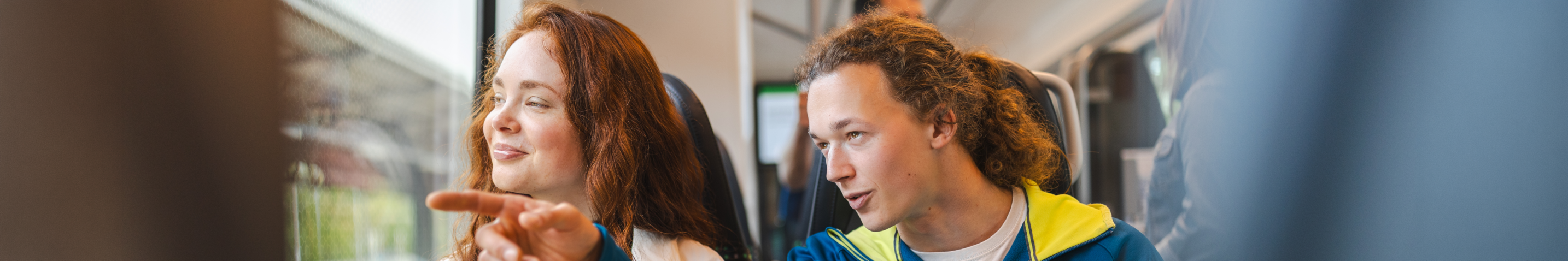 Junge Reisende in der S-Bahn Mitteldeutschland, männlicher Reisende zeigt aus dem Fenster