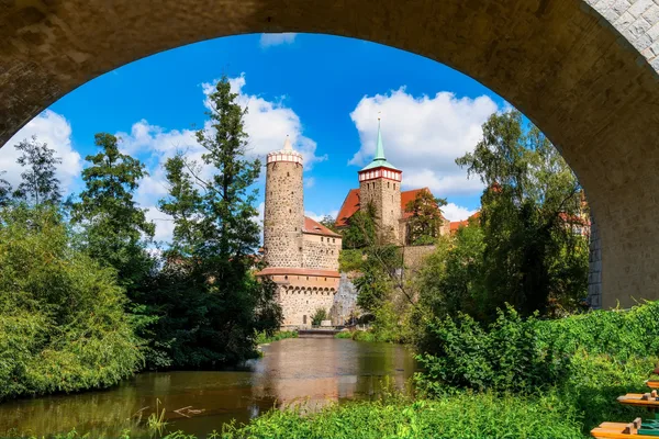Blick durch eine runde Brücke auf die Ortenburg in Bautzen