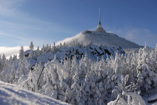 Blick auf den verschneiten Jeschken mit Turm