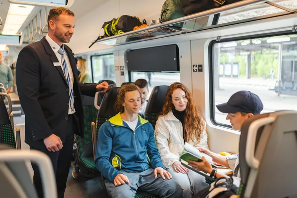 Das Bild zeigt Fahrgäste und einen Fahrgastbetreuer im Mireo-Zug bei der Kontrolle der Fahrscheine.