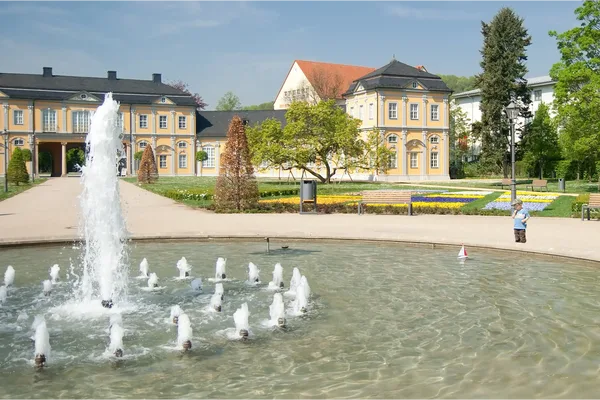 Das Bild zeigt in Gera die Orangerie mit einem Springbrunnen im Vordergrund.