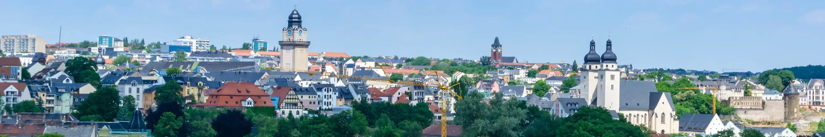 Das Bild zeigt eine Stadtansicht von Plauen im breiten Format mit den markanten Plauener Türmen.