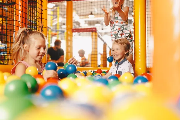 Kinder spielen in einem Bällebad in einem Indoorspielplatz.