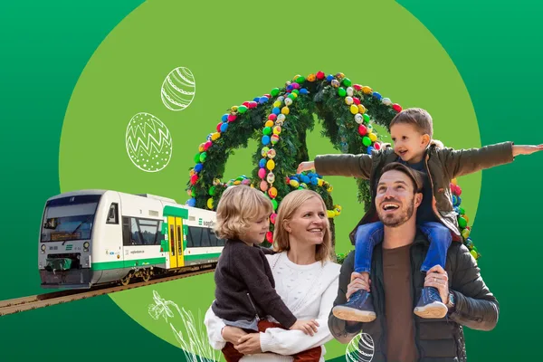 Eine Familie steht im Vordergrund. Im Hintergrund sind die vogtlandbahn und ein traditioneller Osterkranz zu sehen.