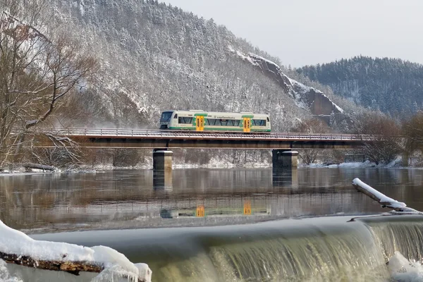 Die Vogtlandbahn fährt im Winter auf einer Brücke über die Weiße Elster und spiegelt sich im Wasser. Fotograf: F. Barteld
