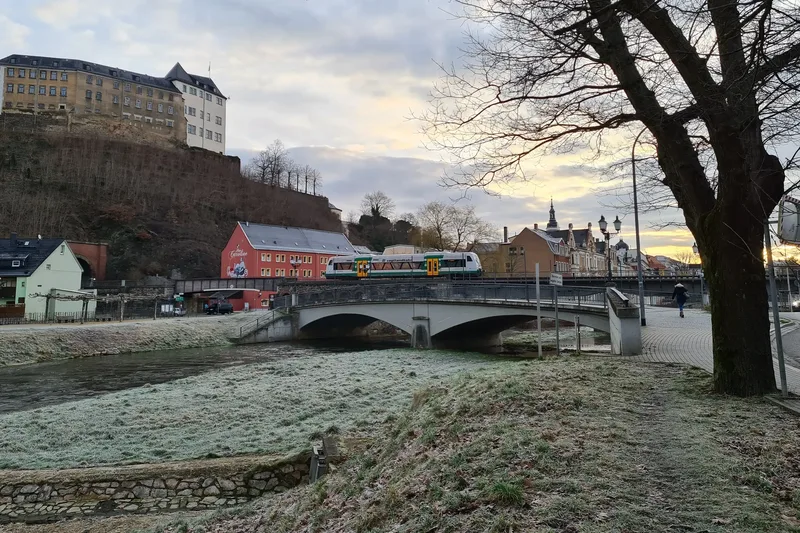 Die Vogtlandbahn fährt im Frühjahr über eine Brücke über die Weiße Elster in Greiz. Fotograf: K. Strauß