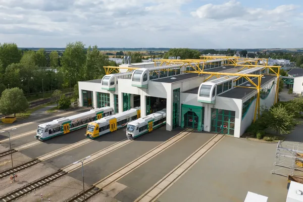 Das Bild zeigt mehrere Fahrzeuge vor dem Werkstattgebäude im Gelände der Die Länderbahn GmbH DLB in Neumark.