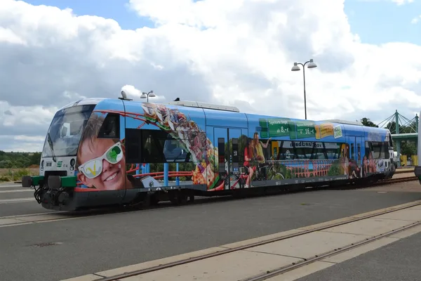 Das Bild zeigt einen Regio-Shuttle der vogtlandbahn mit einer Beklebung mit Vogtland-Motiven aus dem Jahr 2015