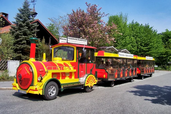 Die rot-gelbe Bimmelbahn fährt mit einer Lok und zwei Wägen durch Bodenmais.