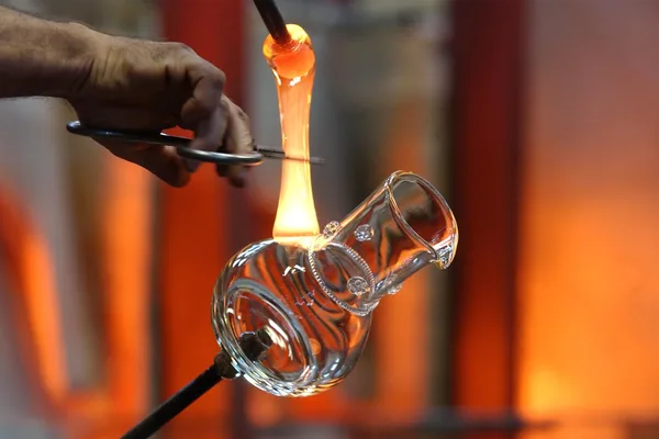 Eine Glasvase wird hergestellt und überschüssiges heiß glühendes Glas wird abgetrennt.